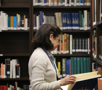 Usuaria consultando un libro en una sala